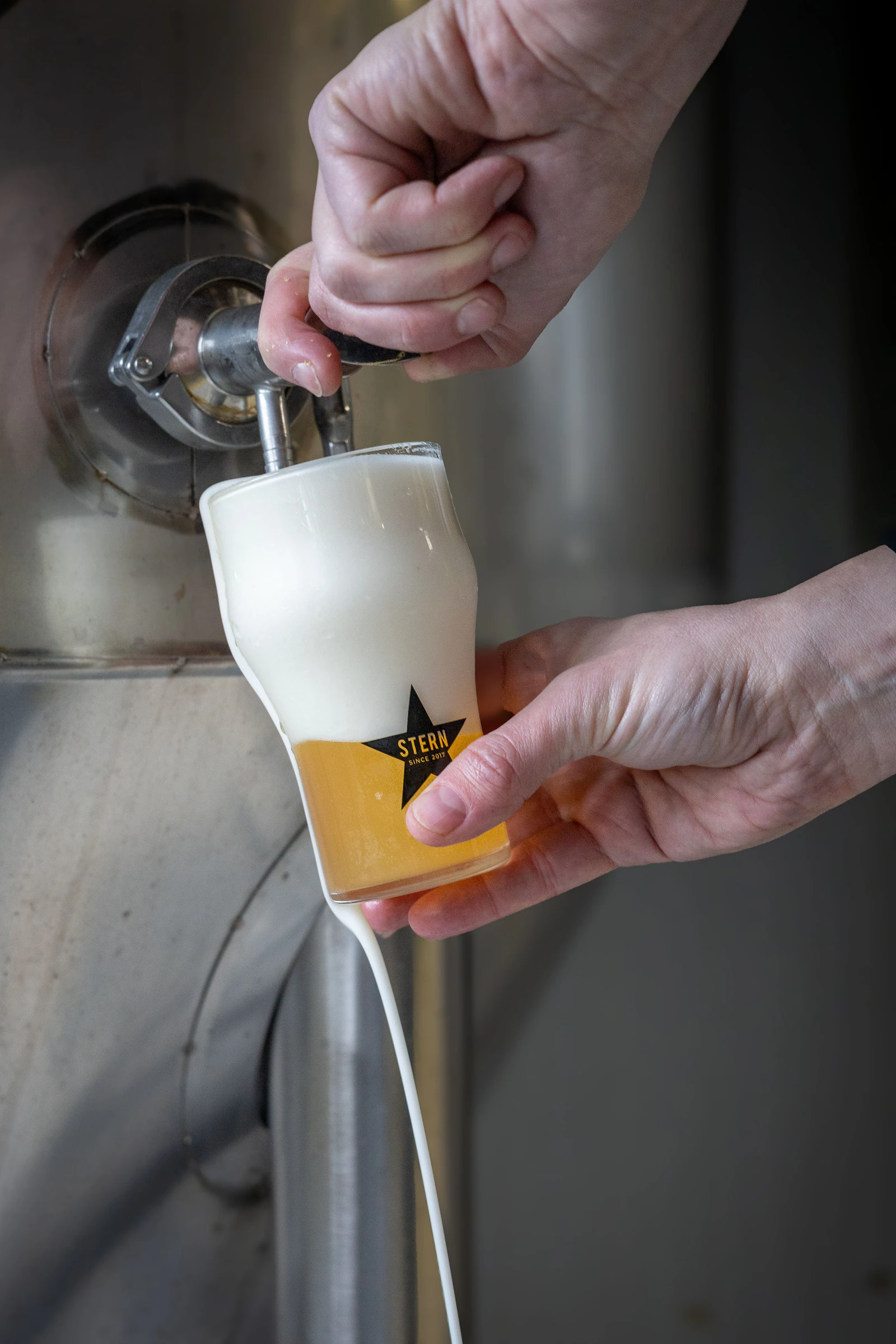 Pivo se točí z tanku do sklenice Stern a pěna přetéká